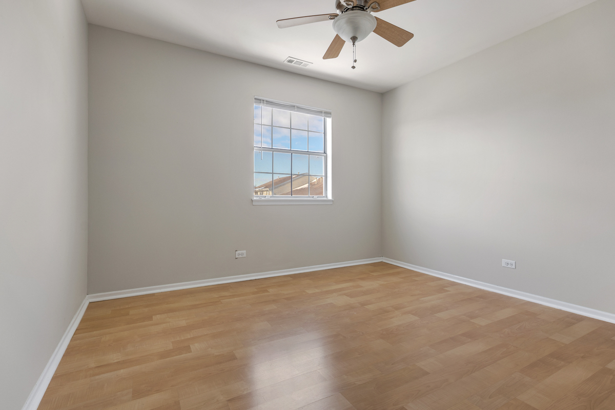 86 Gant Circle, Unit F Streamwood, IL 60107 - Photo 13 of 20 an empty room with a window and a fan