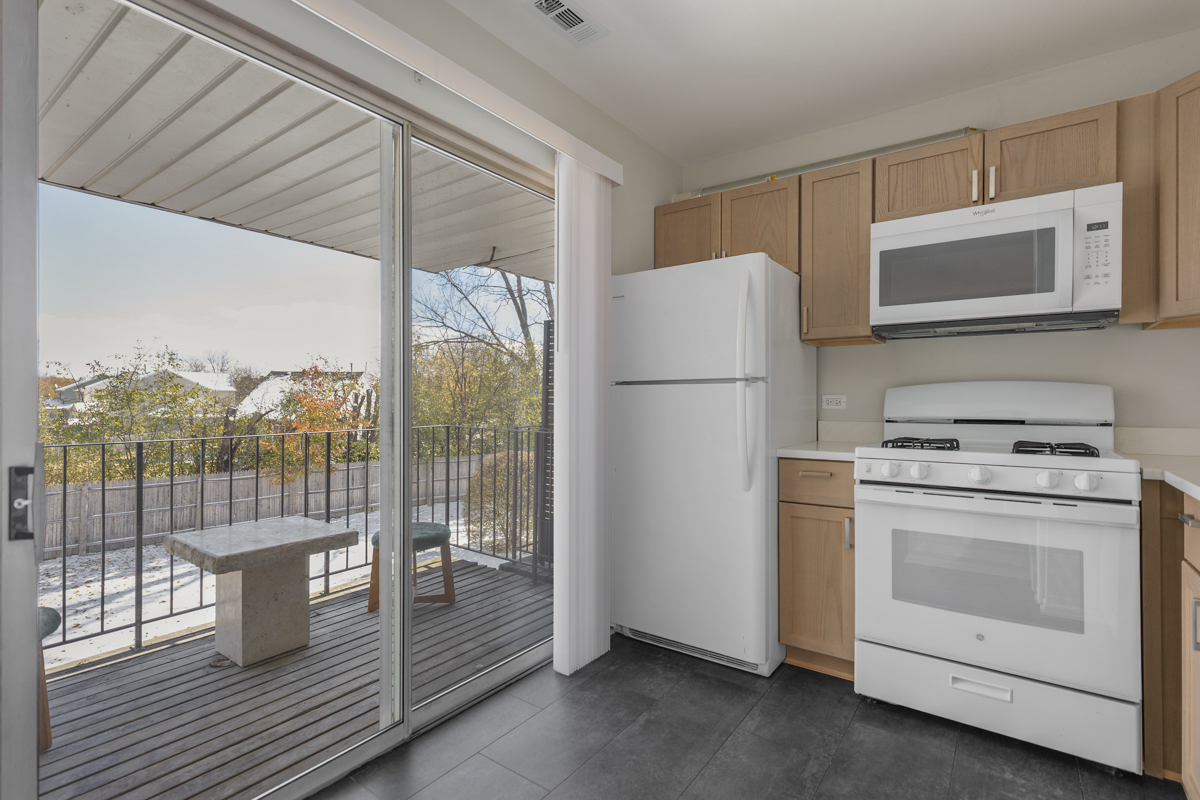 86 Gant Circle, Unit F Streamwood, IL 60107 - Photo 16 of 20 a kitchen with a stove a refrigerator and a cabinets