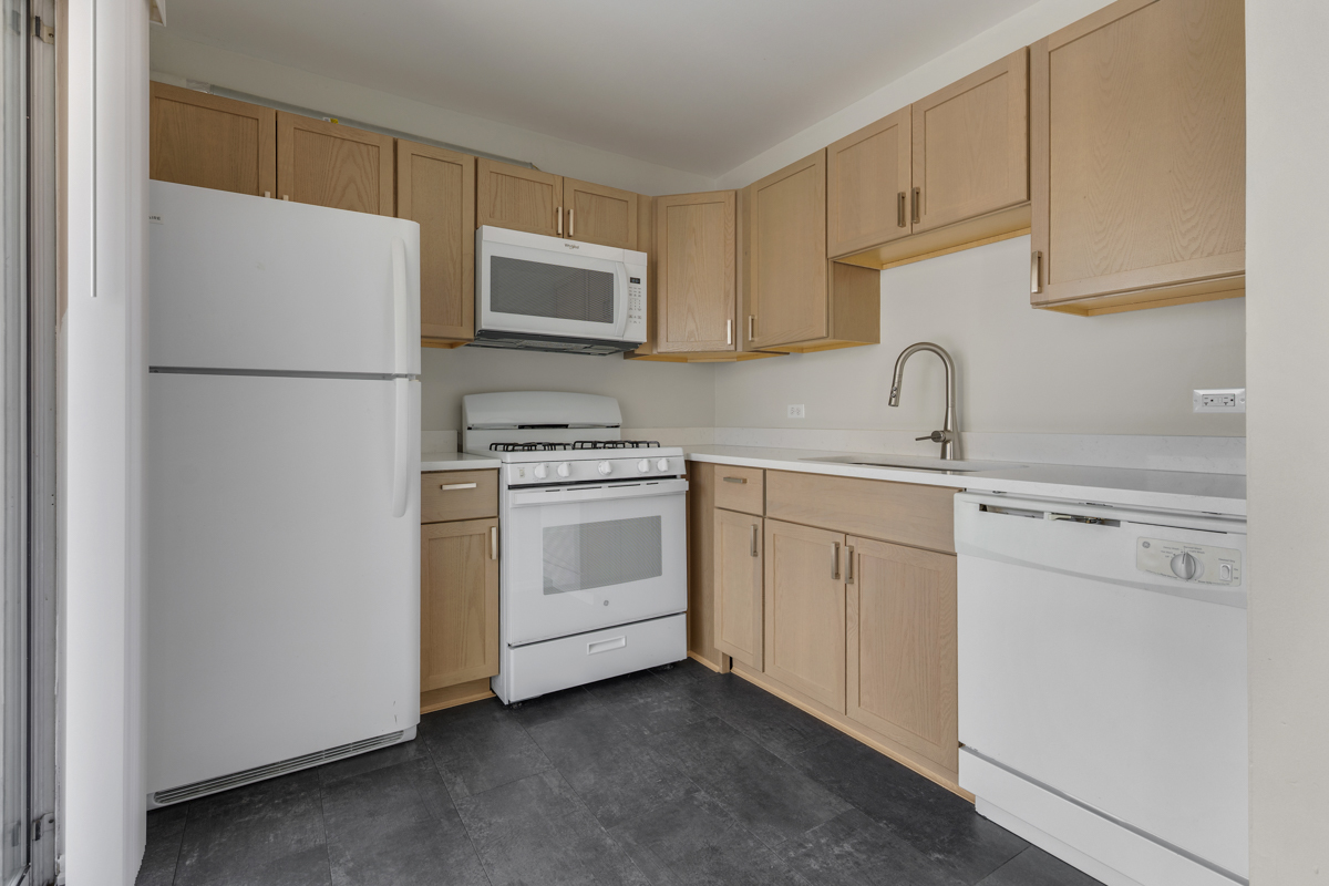 86 Gant Circle, Unit F Streamwood, IL 60107 - Photo 3 of 20 a kitchen with white cabinets sink and white appliances