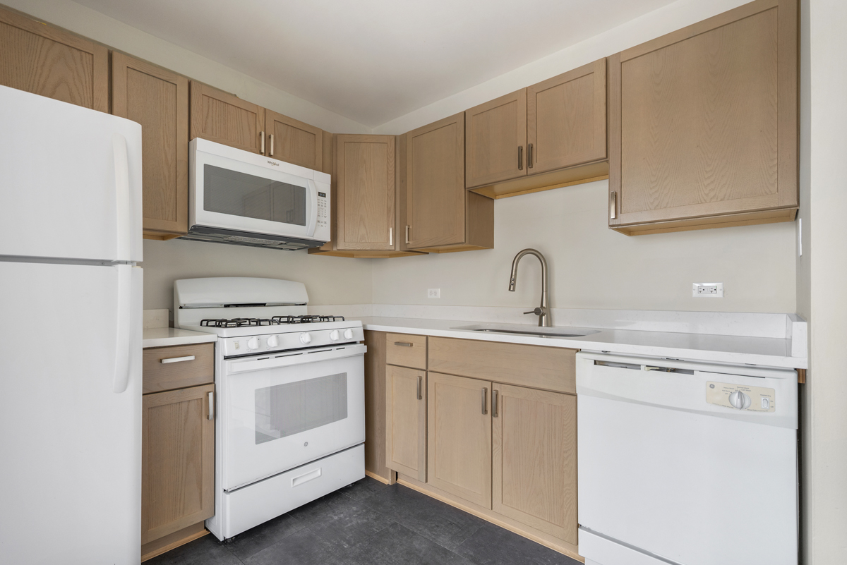 86 Gant Circle, Unit F Streamwood, IL 60107 - Photo 5 of 20 a kitchen with white cabinets sink and white appliances
