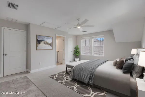 a bedroom with a large bed and a chandelier