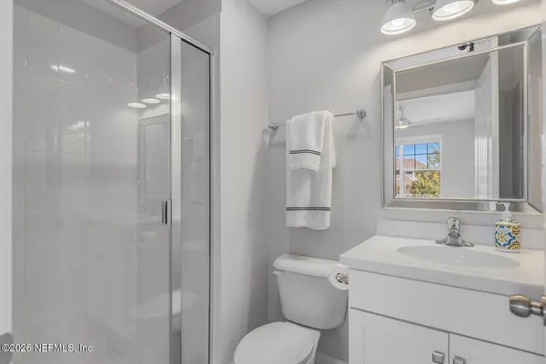 a bathroom with a toilet sink vanity and shower
