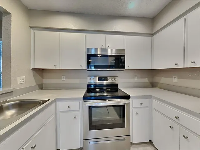 a kitchen with appliances a sink and cabinets