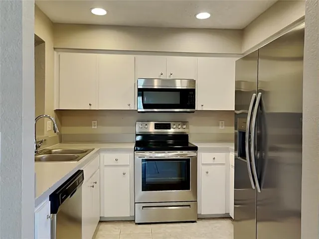 a kitchen with a sink appliances and cabinets