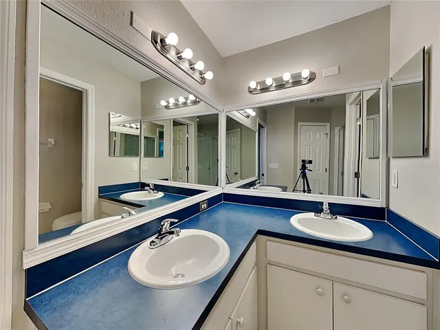 a bathroom with a sink double vanity granite and a mirror