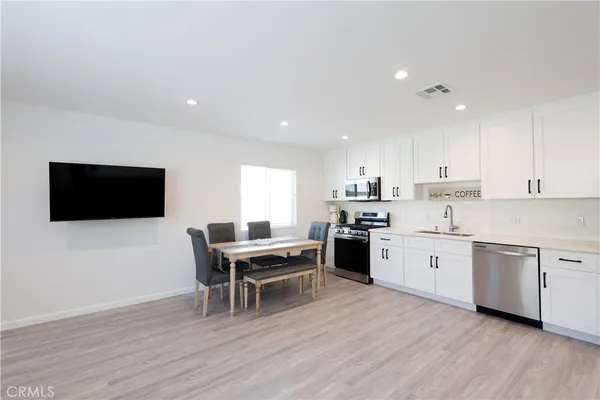 a kitchen with a sink cabinets and wooden floor