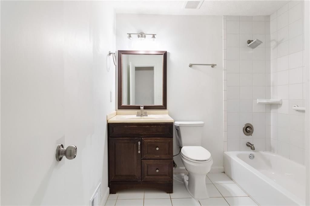 584 Fieldstream Way Northwest Lawrenceville, GA 30044 - Photo 12 of 20 a bathroom with a granite countertop sink a toilet and shower