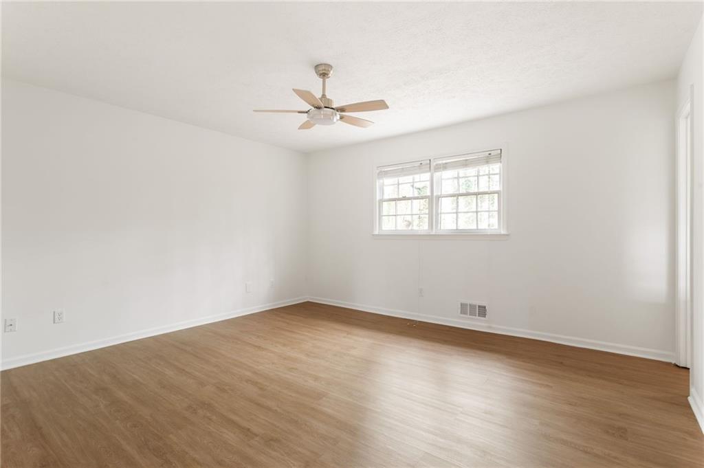 584 Fieldstream Way Northwest Lawrenceville, GA 30044 - Photo 13 of 20 an empty room with wooden floor fan and windows