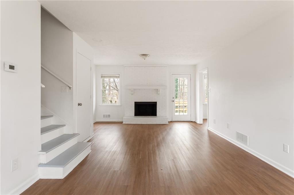 584 Fieldstream Way Northwest Lawrenceville, GA 30044 - Photo 4 of 20 wooden floor in an empty room with a fireplace