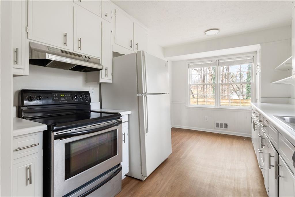 584 Fieldstream Way Northwest Lawrenceville, GA 30044 - Photo 9 of 20 a kitchen with appliances cabinets and a wooden floor