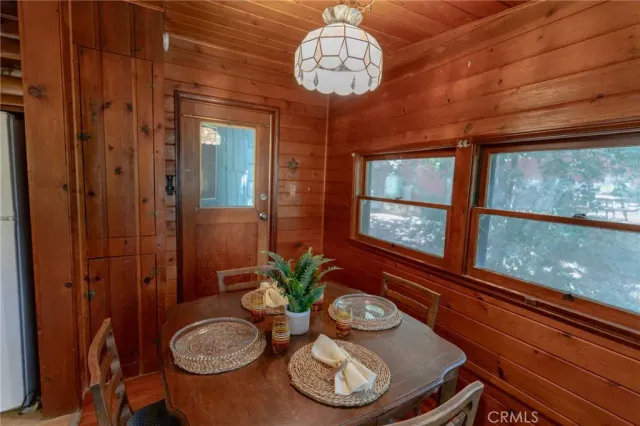 a view of a dining room with furniture a chandelier and wooden floor