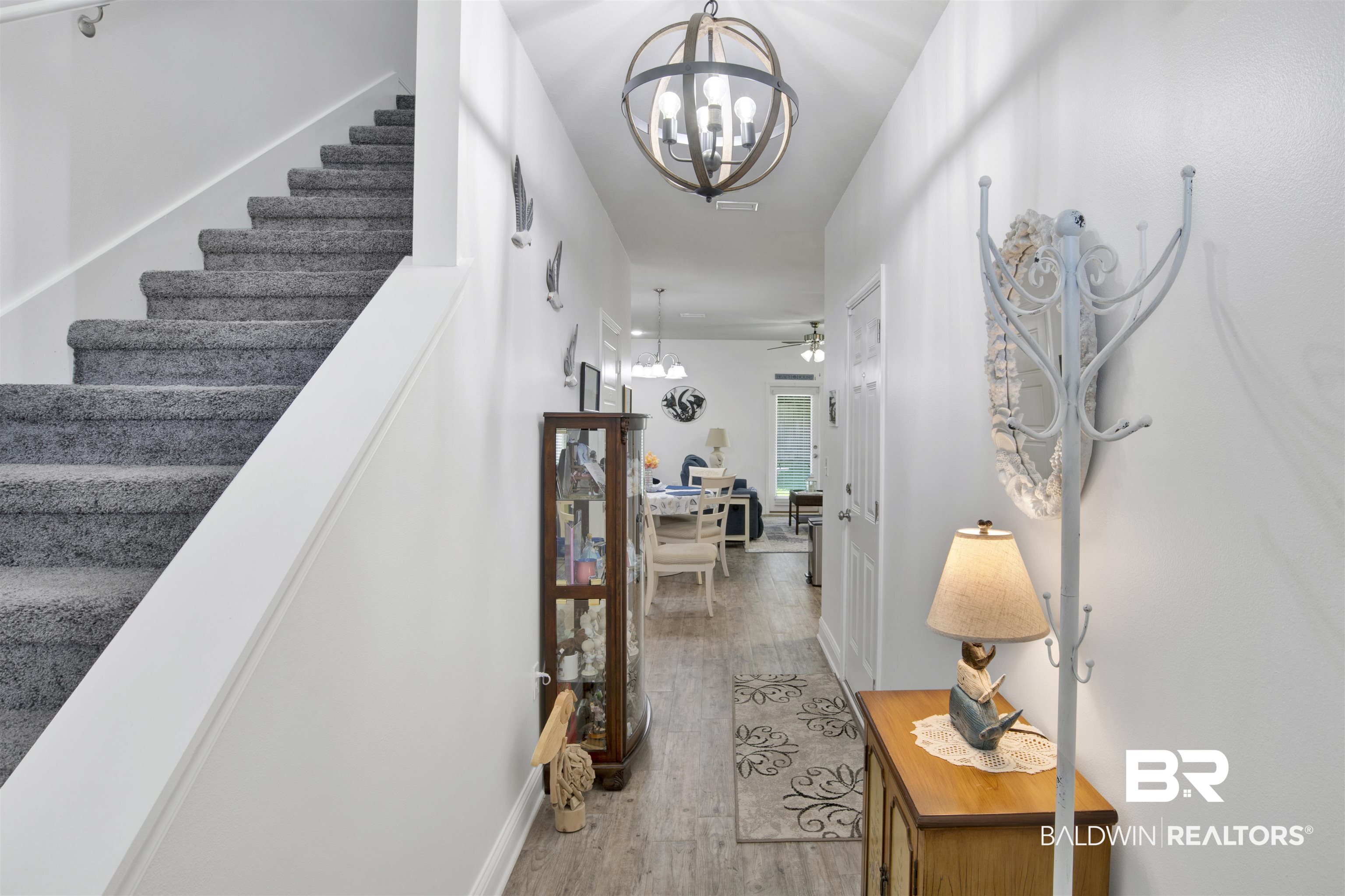 25806 Pollard Road, Unit 20 Daphne, AL 36526 - Photo 13 of 29 Hallway featuring wood-type flooring and a notable chandelier