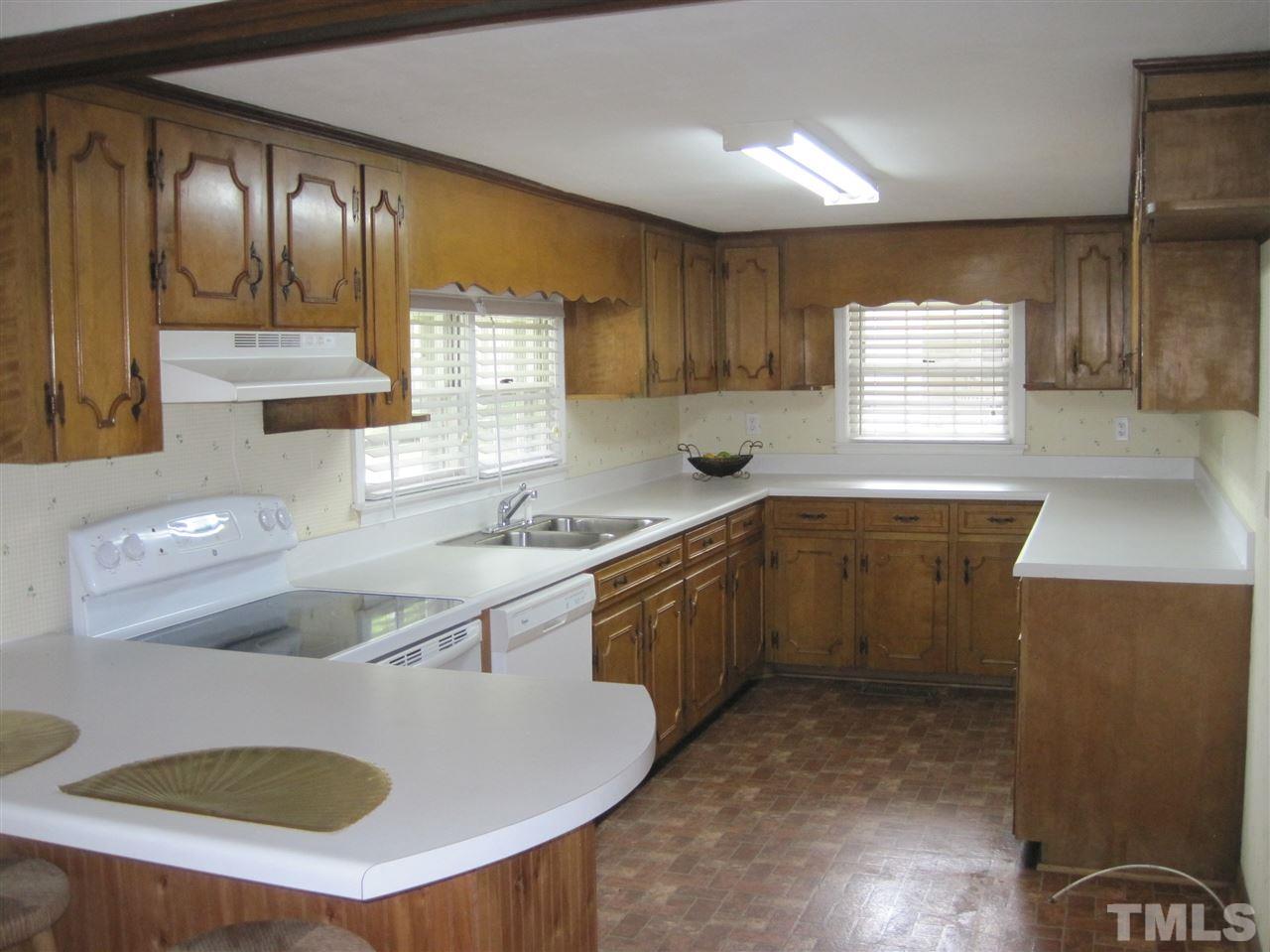 1321 West Core Road Dunn, NC 28334 - Photo 2 of 18 a kitchen with a sink a stove cabinets and a window