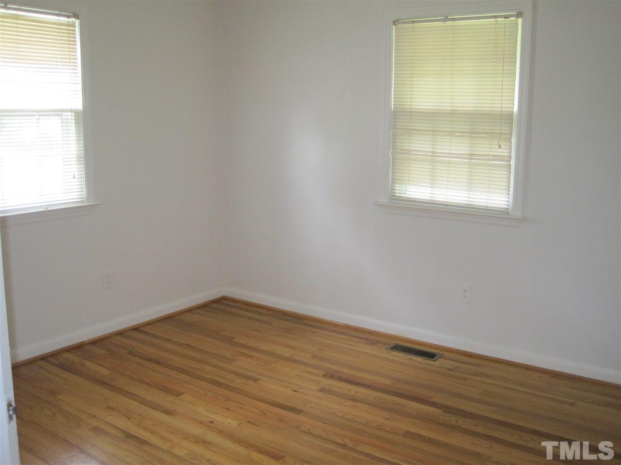 1321 West Core Road Dunn, NC 28334 - Photo 12 of 18 an empty room with wooden floor and windows