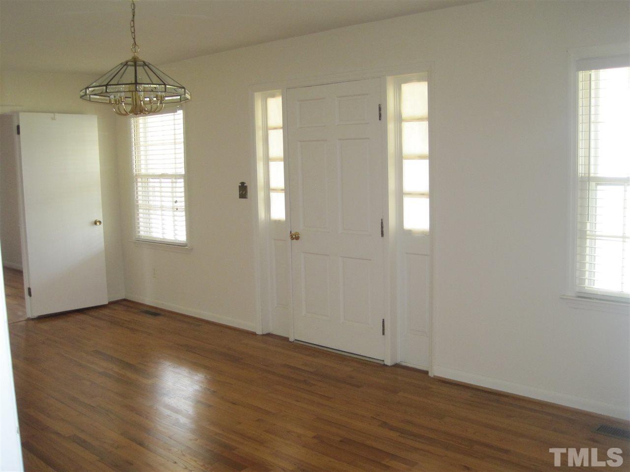 1321 West Core Road Dunn, NC 28334 - Photo 13 of 18 an empty room with wooden floor and windows