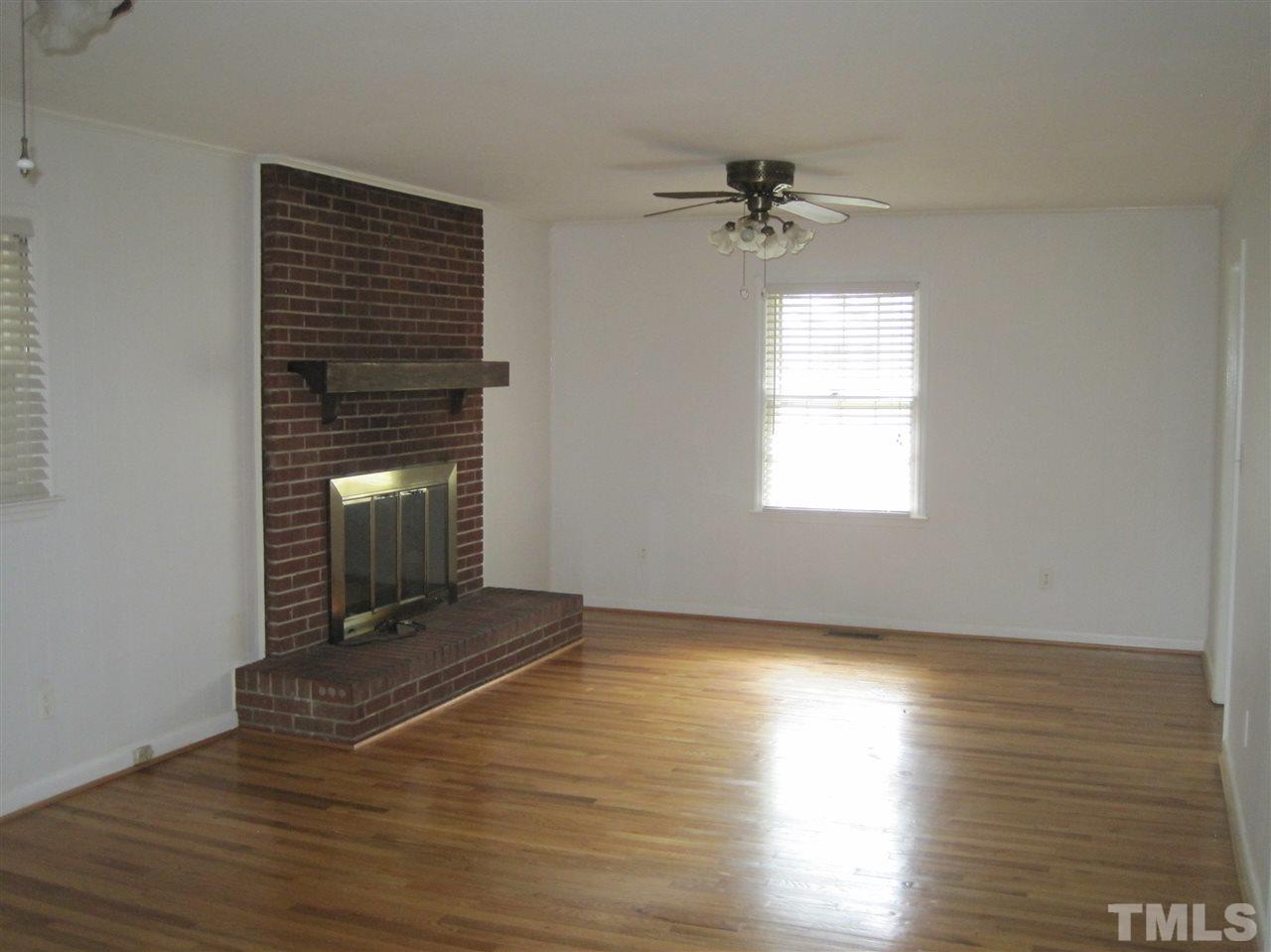 1321 West Core Road Dunn, NC 28334 - Photo 4 of 18 an empty room with wooden floor a ceiling fan and windows