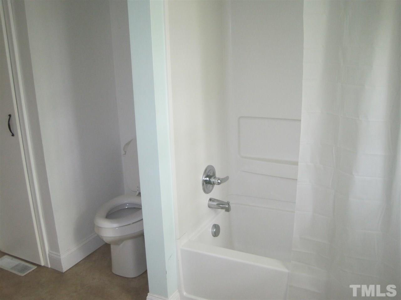 1321 West Core Road Dunn, NC 28334 - Photo 10 of 18 a bath room with a toilet and a bath tub