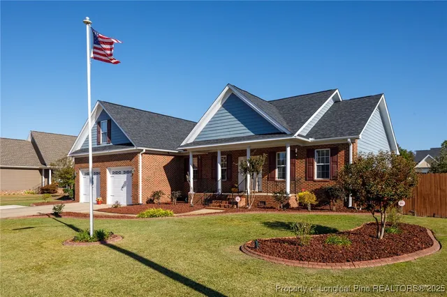 a view of a house with backyard and sitting area