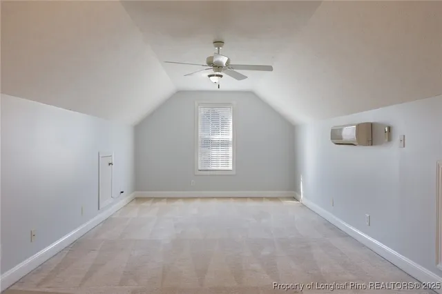 an empty room with a window and a chandelier fan