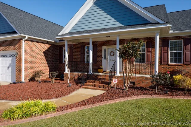 a view of house with backyard and outdoor seating