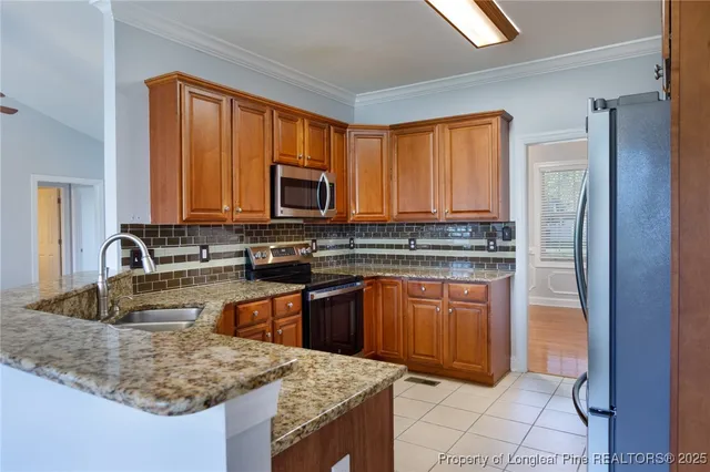 a kitchen with stainless steel appliances granite countertop a refrigerator stove and sink