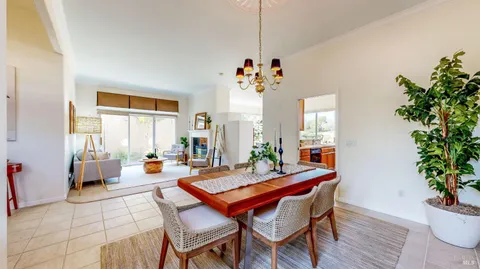 a dining room with furniture potted plants and wooden floor