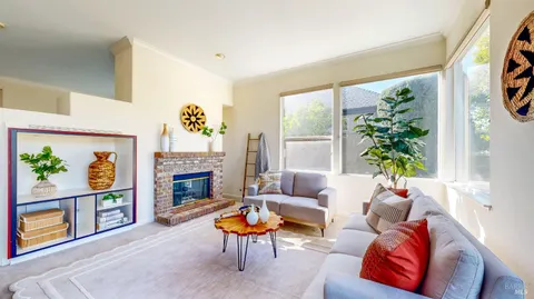 a living room with furniture a window and a potted plant