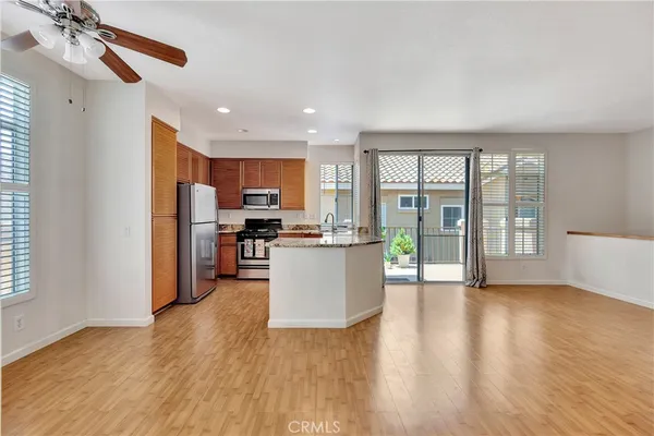 a view of kitchen with kitchen island wooden floor center island and stainless steel appliances