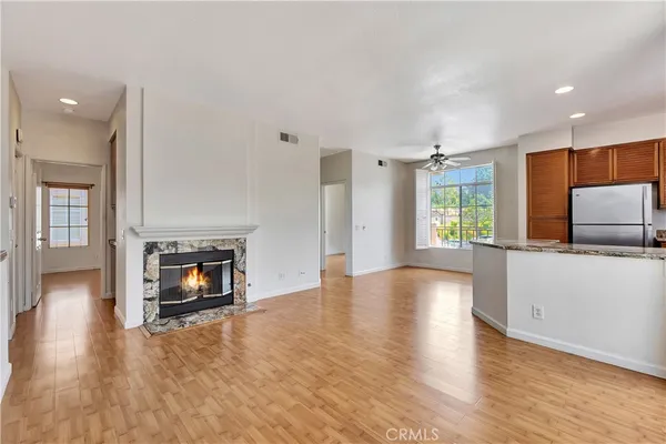 a view of empty room with wooden floor and fireplace