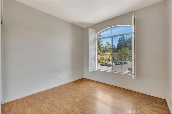 an empty room with wooden floor and a window