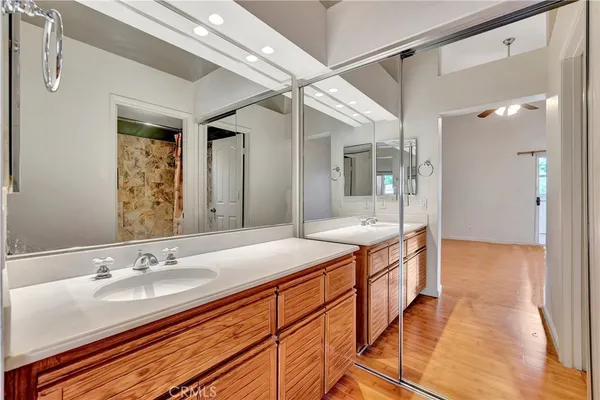 a bathroom with a granite countertop sink a mirror and a shower