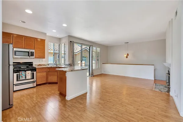 a large kitchen with stainless steel appliances a large counter top a stove and a refrigerator