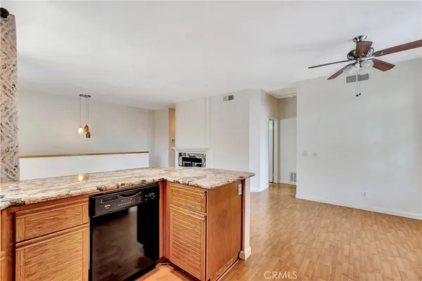a kitchen with granite countertop a sink cabinets and stainless steel appliances