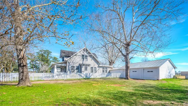 a front view of house with yard and tree in front of it