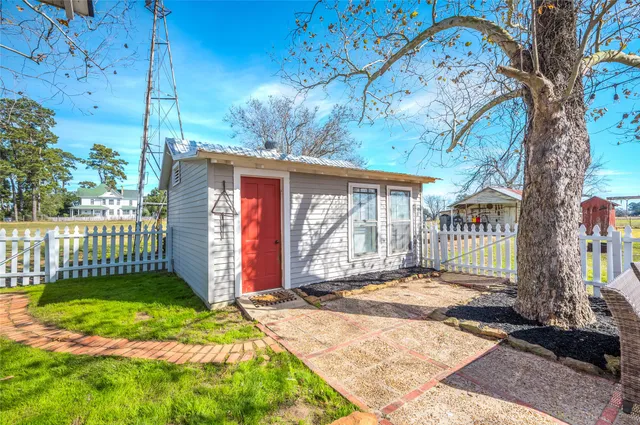 a view of a house with a small yard and wooden fence