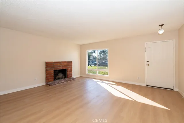 an empty room with floor to ceiling window and fireplace