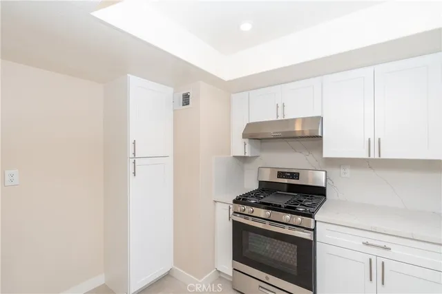 a kitchen with stainless steel appliances white cabinets and a stove