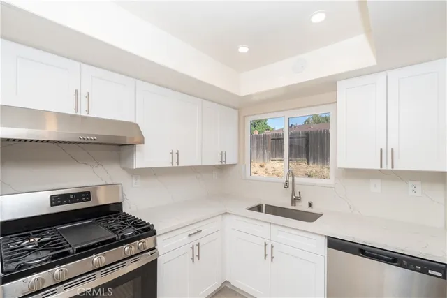 a kitchen with a sink stove top oven and cabinets