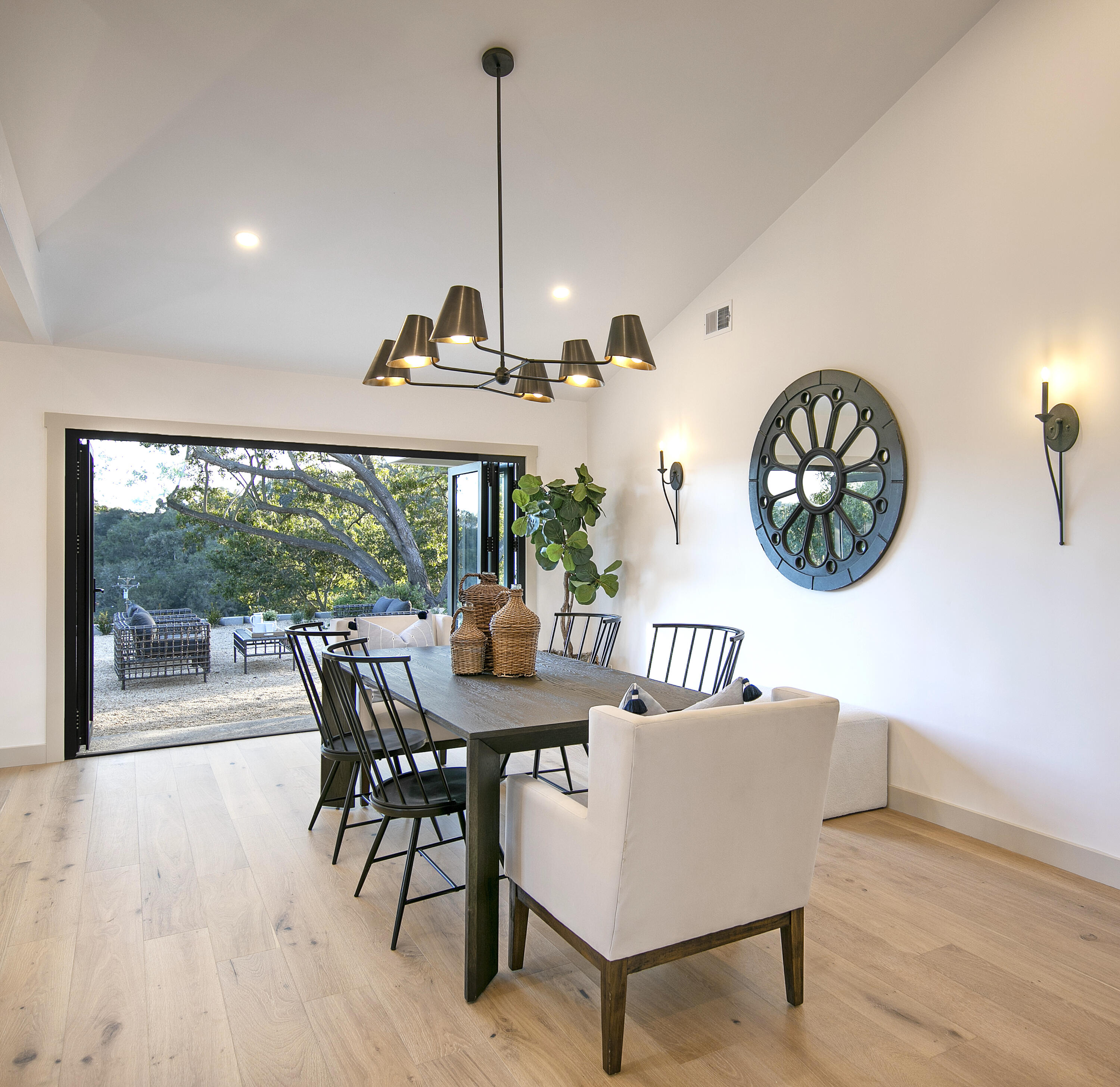 1514 Crestline Drive Santa Barbara, CA 93105 - Photo 8 of 25 a view of a dining room and a livingroom with furniture wooden floor a rug a fireplace and a chandelier