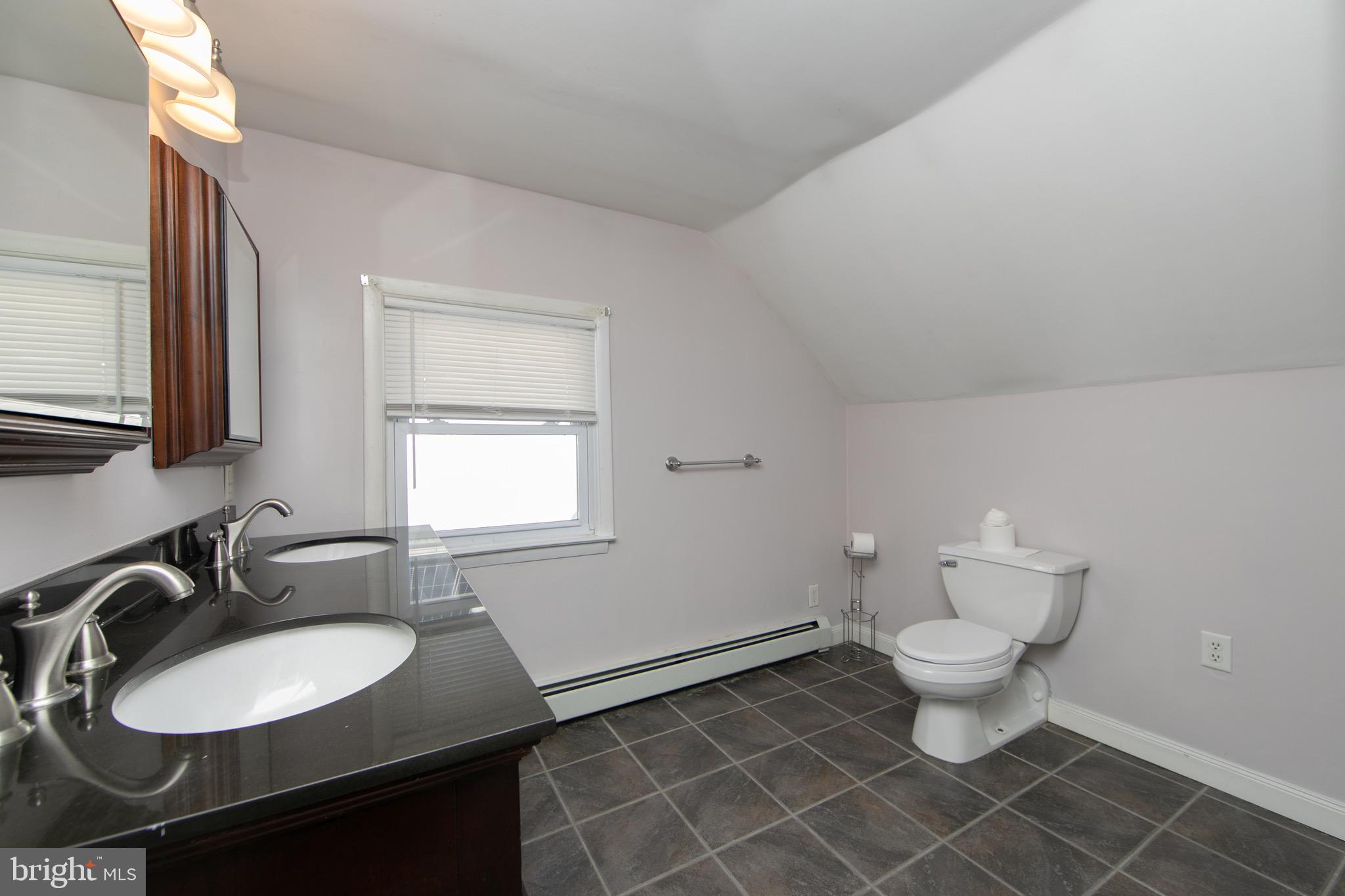553 Maple Avenue Audubon, NJ 08106 - Photo 27 of 49 a bathroom with a sink toilet a mirror and a window