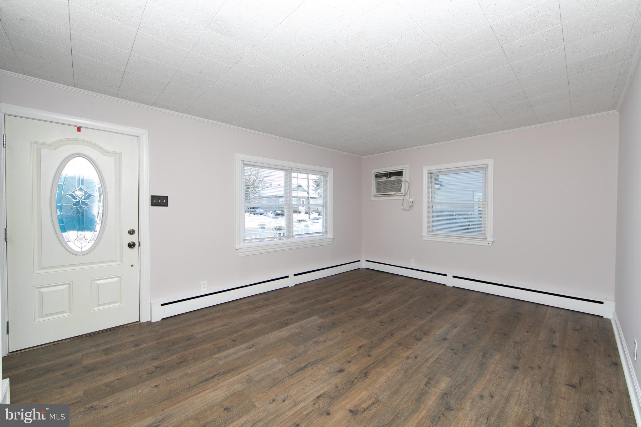 553 Maple Avenue Audubon, NJ 08106 - Photo 3 of 49 an empty room with wooden floor mirror and windows