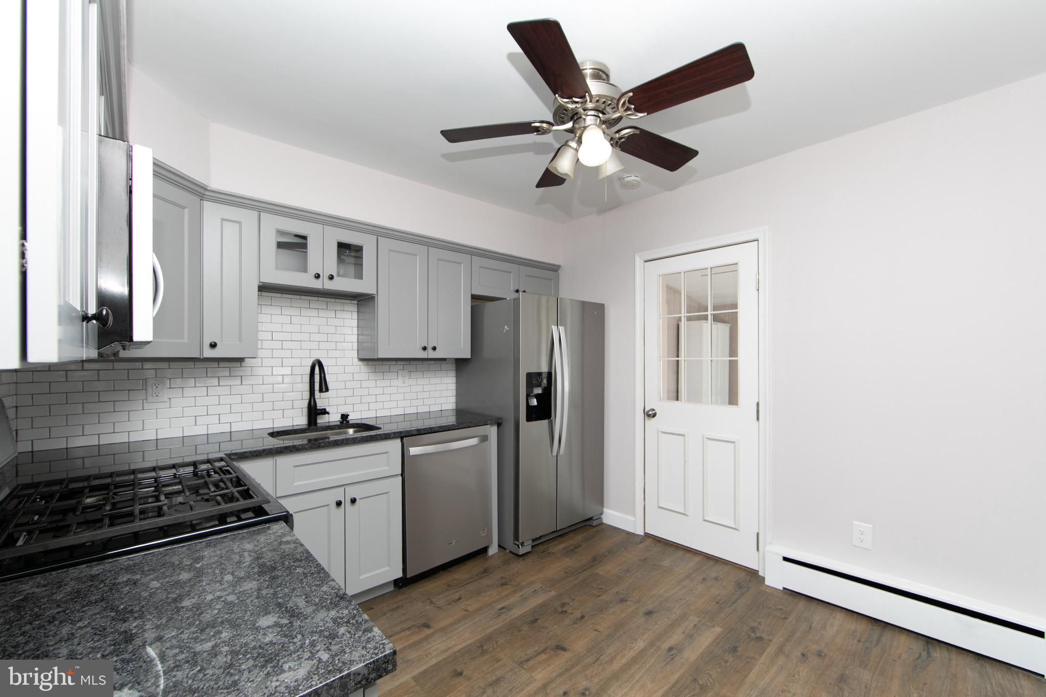 553 Maple Avenue Audubon, NJ 08106 - Photo 5 of 49 a kitchen with stainless steel appliances granite countertop a sink a stove a refrigerator cabinets and wooden floor