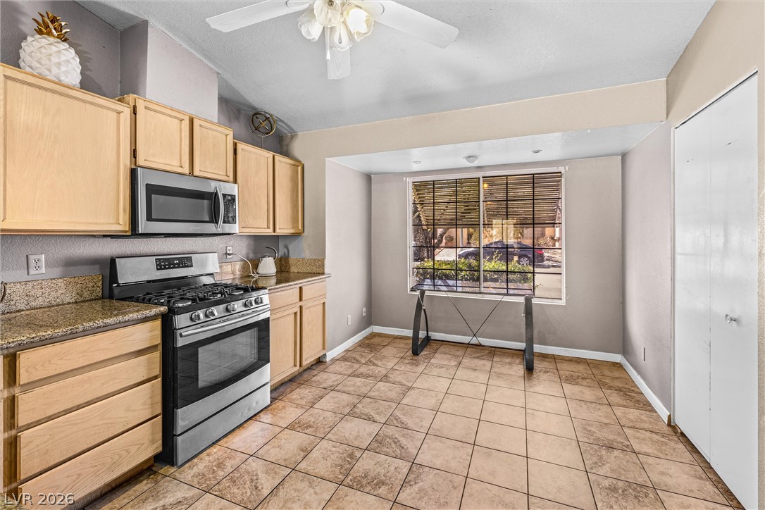 1624 Palmae Way Las Vegas, NV 89128 - Photo 5 of 18 Functional kitchen with ample cabinet space, a gas range, and a large window for natural light.