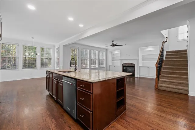 a kitchen with stainless steel appliances granite countertop a stove and a wooden floors
