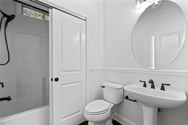 a bathroom with a sink a toilet and a mirror