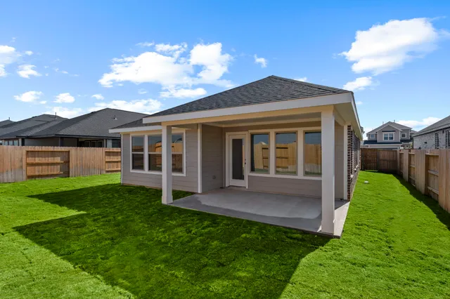 a view of a house with a yard and a large tree
