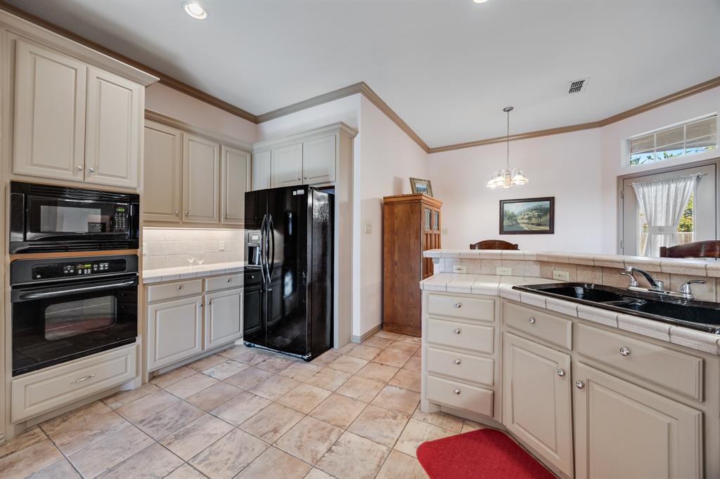 155 Lexington Drive Terrell, TX 75160 - Photo 13 of 27 a kitchen with a refrigerator sink and cabinets
