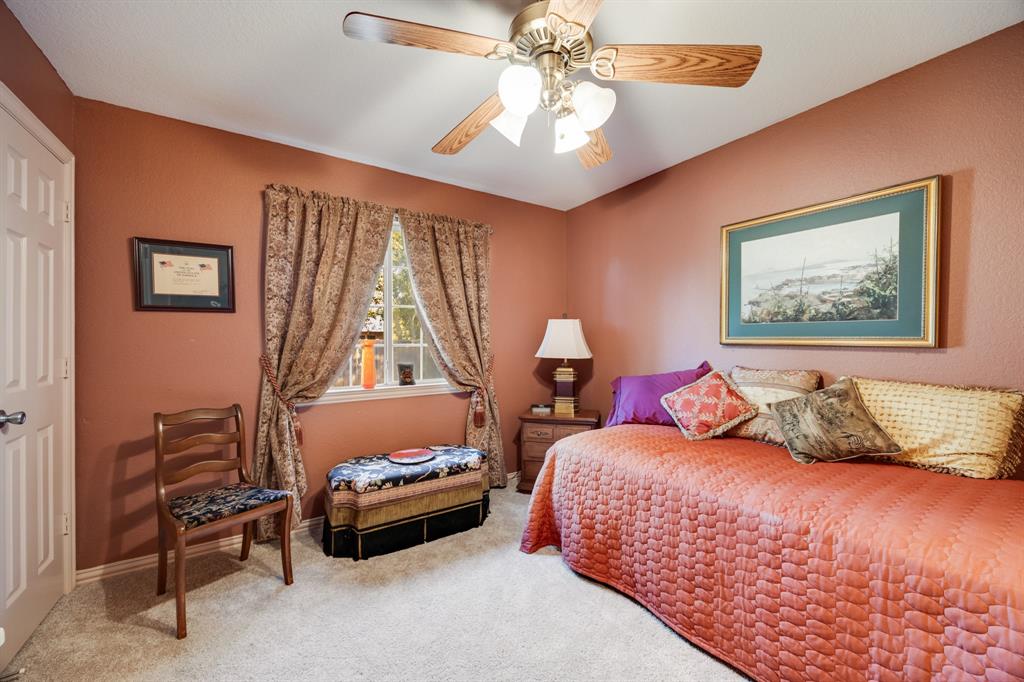 155 Lexington Drive Terrell, TX 75160 - Photo 21 of 27 a bedroom with a bed and a chandelier