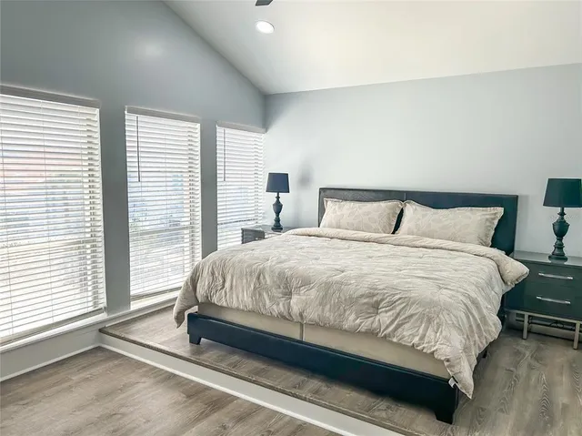 a large bed sitting in a bedroom next to a window
