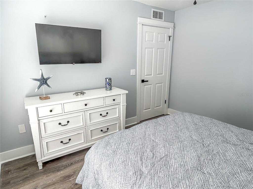 315 Medallion Boulevard, Unit F Madeira Beach, FL 33708 - Photo 13 of 18 a bedroom with a bed and a flat screen tv